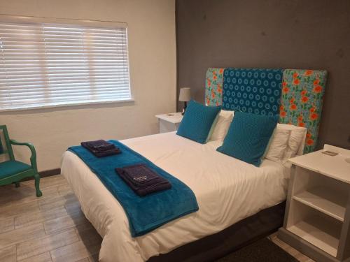 a bedroom with a large bed with blue pillows at Sunshine Cottage in Pennington