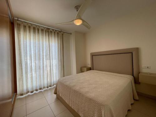 a bedroom with a bed and a large window at Terrasol Torrelitoral Ático 1 Dormitorio in Torre del Mar