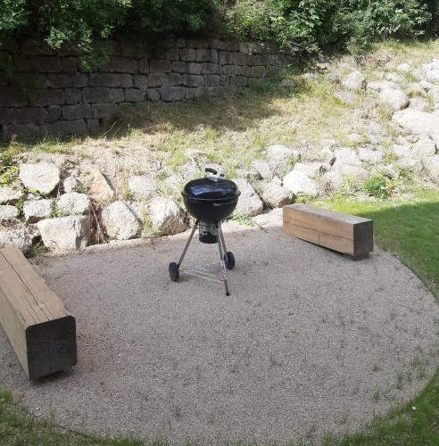a grill sitting on the ground next to a stone wall at Apartmán Amálie in Albrechtice v Jizerských horách