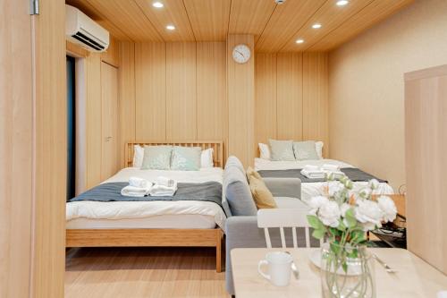 大阪Value Osaka Tengachaya Namba Condo的一间卧室设有两张床和一张花瓶桌子。