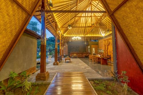 an external view of a house with a large roof at Taman Bidadari Eco Wellness in Pemuteran
