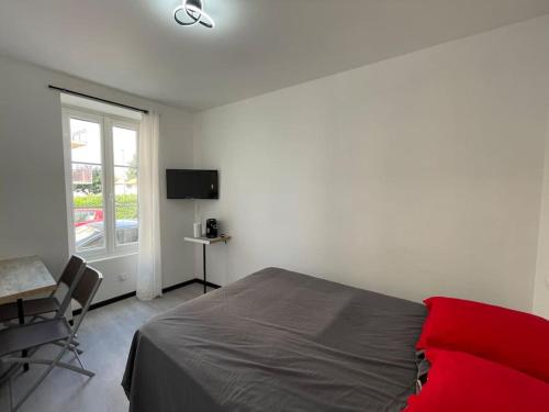 a bedroom with a bed and a desk and a window at Studio A2 18m2 cosy 5minutes Gare Parking gratuit Rue de La Mure in Roanne