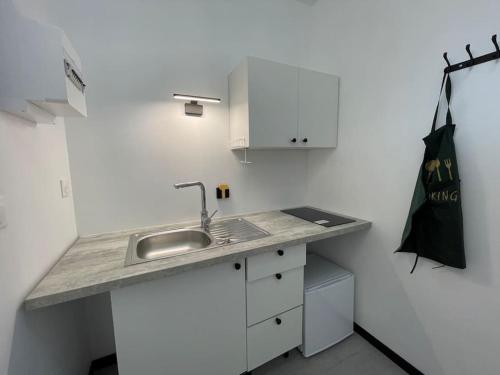 a kitchen with a sink and a black bag on the wall at Studio A2 18m2 cosy 5minutes Gare Parking gratuit Rue de La Mure in Roanne