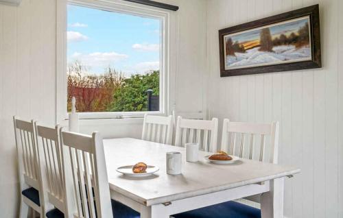 a white table and chairs in a room with a window at Lovely Summer House By Venø Bay in Vinderup
