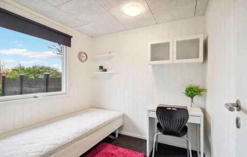 a small white room with a desk and a chair at Lovely Summer House By Venø Bay in Vinderup