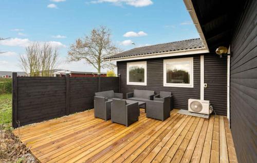 a patio with chairs and a tv on a wooden deck at Lovely Summer House By Venø Bay in Vinderup