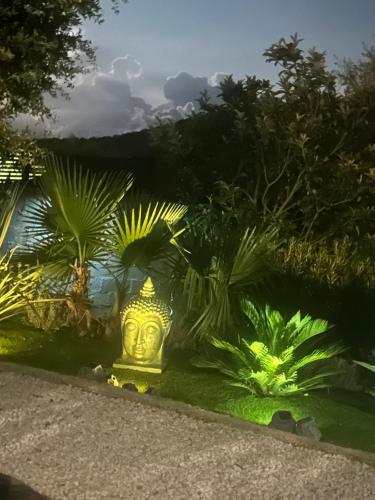 a garden with a gold statue in the grass at Petit Havre de Paix avec Jacuzzi Luxe & Jardin Privatif Zen in Cavalaire-sur-Mer