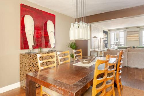 une salle à manger avec une table et des chaises en bois dans l'établissement Miro Mirage, à Paris