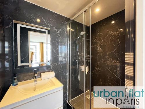 une salle de bain avec un lavabo et une douche en verre dans l'établissement Urban Flat 129 - Sublime Art Love Champs-Elysees, à Paris