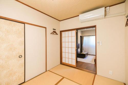 an empty room with a door and a living room at 湯乃荘 in Hakone