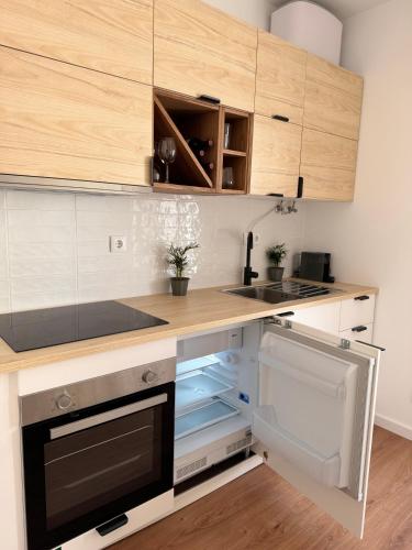 a kitchen with wooden cabinets and a stove top oven at Salty Apartments in Nazaré