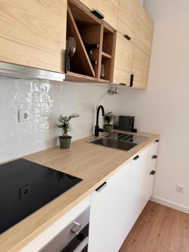 a kitchen with white and black cabinets and a sink at Salty Apartments in Nazaré