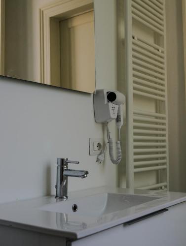 a bathroom sink with a hair dryer next to a mirror at FEEL - Mille Suites in Bergamo