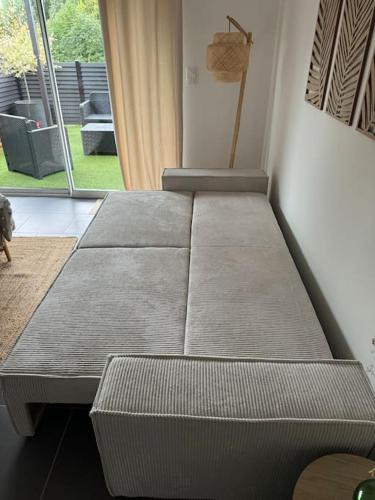 a bed sitting in a room next to a window at Logement cosy proche plage wissant in Marquise