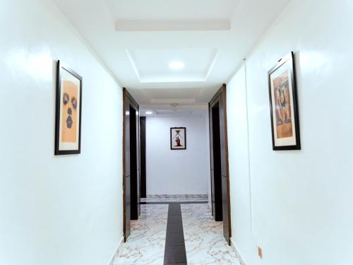 a hallway with two paintings on the walls and a hallway with two doors at 247 Luxury Hotel in Lekki