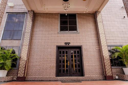 a brick building with a black door on it at 247 Luxury Hotel in Lekki
