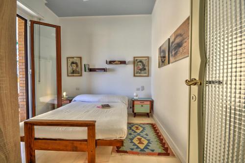 a small bedroom with a bed and a door at Ca' Muna - Sea View Penthouse, Private Rooftop, Walking to the Beach in Rapallo