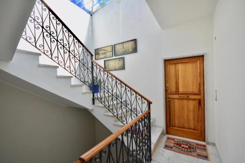 a staircase in a house with a wooden door at Ca' Muna - Sea View Penthouse, Private Rooftop, Walking to the Beach in Rapallo