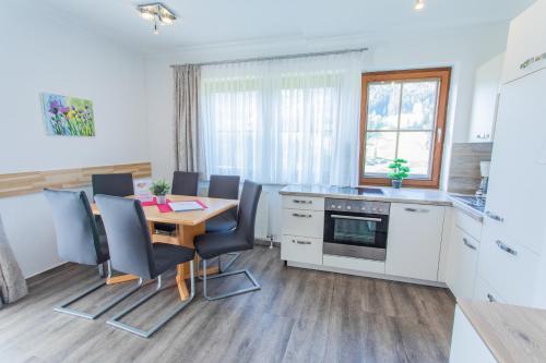 a kitchen with a dining room table and chairs at Huberhof 5 by Alpenidyll Apartments in Rohrmoos