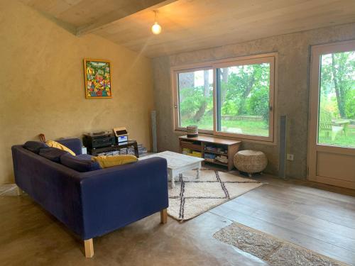un salon avec un canapé bleu et une table dans l'établissement Chambre d'hôte, à Monflanquin