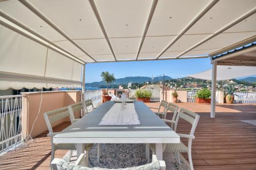 a long table on a deck with chairs at Ca' Muna - Sea View Penthouse, Private Rooftop, Walking to the Beach in Rapallo