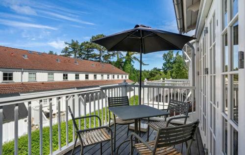 a table and chairs on a balcony with an umbrella at Modern And Luxurious Holiday Apartment In Rørvig in Rørvig