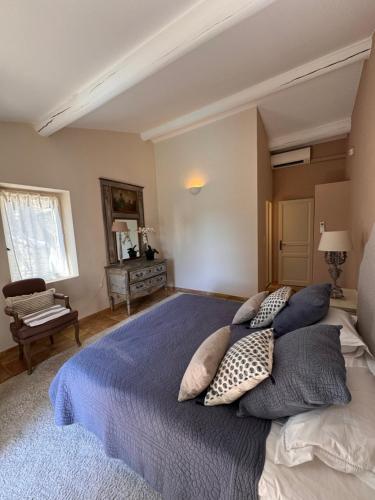 une chambre avec un grand lit avec des oreillers dessus dans l'établissement Le Clos de Manon, à Gordes