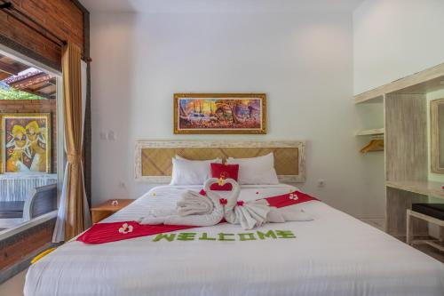 a bedroom with a large bed with towels on it at Taman Bidadari Eco Wellness in Pemuteran