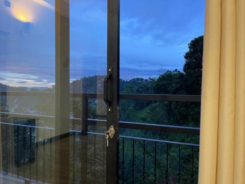 a door to a balcony with a view at Lush Breeze in Kandy