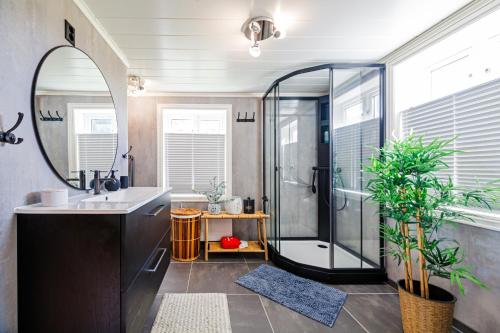 a bathroom with a shower and a sink and a mirror at The Haukland House, Between Peaks & Sea in Leknes