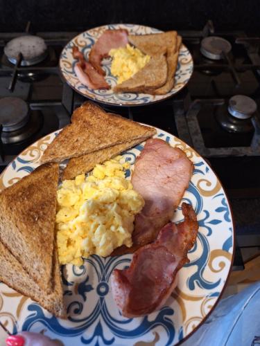 two plates of breakfast food with eggs bacon and toast at Ballnamona house in Cong