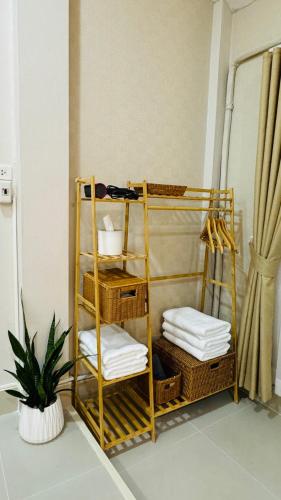 a room with a rack with towels and baskets at Vela House Hatyai in Hat Yai