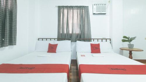 Ένα ή περισσότερα κρεβάτια σε δωμάτιο στο RedDoorz at Joel's Apartelle