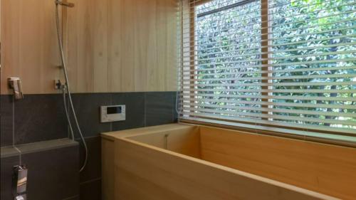 a bathroom with a bath tub and a window at NIPPONIA HOTEL NARA NARAMACHI in Nara
