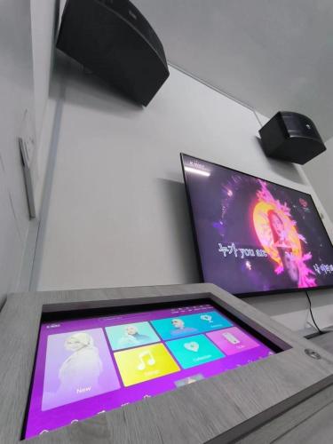 a tablet sitting on a table next to a tv at Nieo Village 1 in Port Dickson