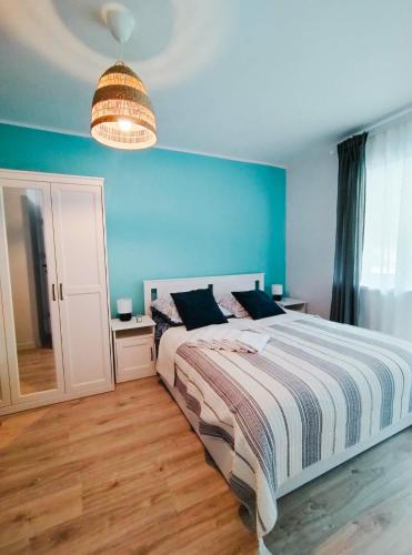 a bedroom with a bed and a blue wall at Róża Wiatrów Leśny Klif in Debina
