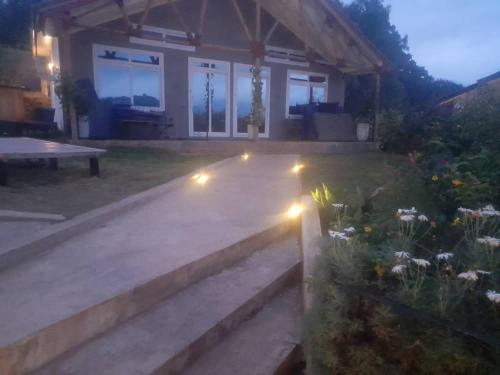 a house with lights in the yard at night at Boulevard Inn Mt Meru in Arusha