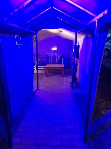 a dark room with a bench and purple lights at Boulevard Inn Mt Meru in Arusha