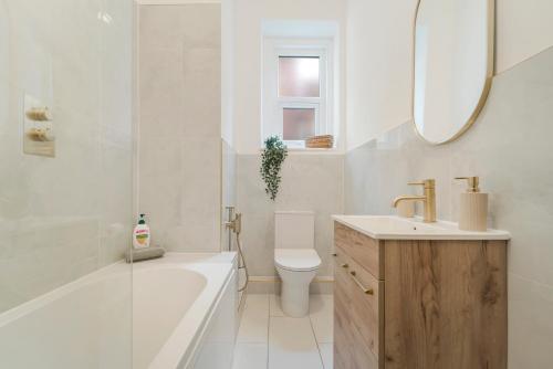 a bathroom with a tub and a toilet and a sink at Modern Two Bedroom Central Flat in Weston-super-Mare