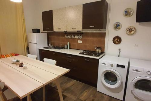 a kitchen with a table and a washing machine at Apartament w Welskiej Kamienicy in Lidzbark