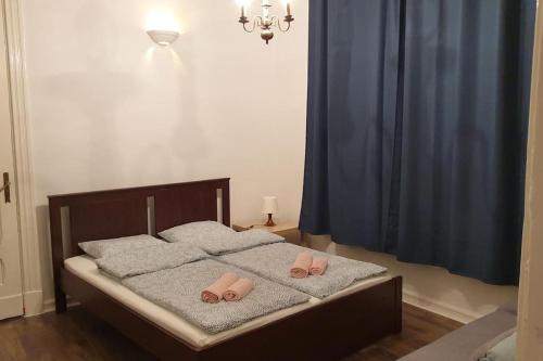 a bed with two pairs of pink slippers on it at Apartament w Welskiej Kamienicy in Lidzbark