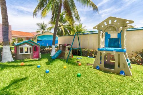 einen Hof mit Spielplatz mit Schaukel in der Unterkunft Posada Real Ixtapa in Ixtapa