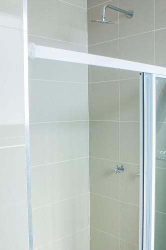 a shower with a glass door in a bathroom at Ausblick Guest House - State House in Windhoek