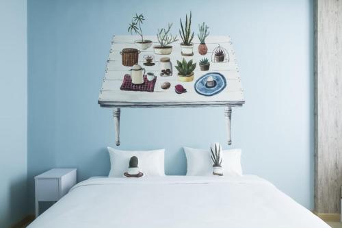 a bed with plants on a shelf above it at Beat Hotel Bangkok in Bangkok