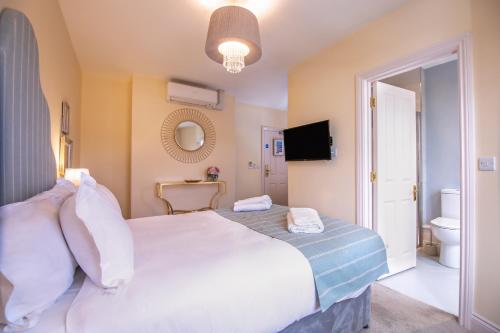 a bedroom with a large white bed and a bathroom at Caboose in Salisbury