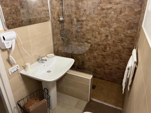 a bathroom with a sink and a shower at Madre Terra Airport Apartment & Rooms in Terrasini