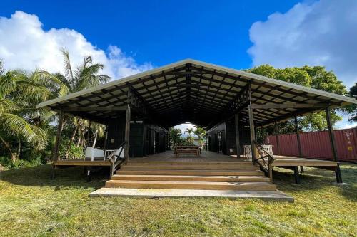 a pavilion with benches and a table on the grass at The Pavilion - Rarotonga in Arorangi