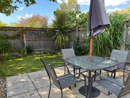 a table and chairs with an umbrella on a patio at Walnut Corner in Heacham