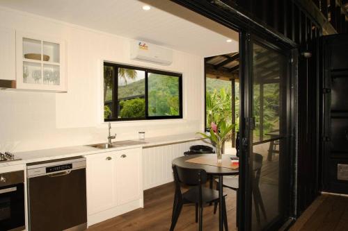 a kitchen with a table and a sink and a window at The Pavilion - Rarotonga in Arorangi