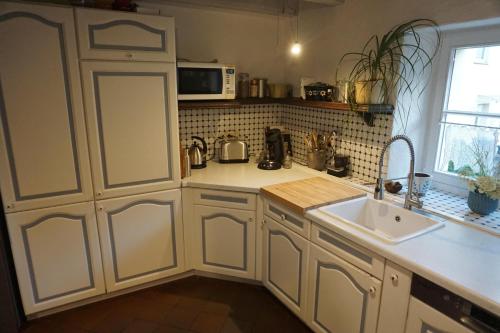 a kitchen with white cabinets and a sink at Ferienhaus Glücksnest in Hetzerath